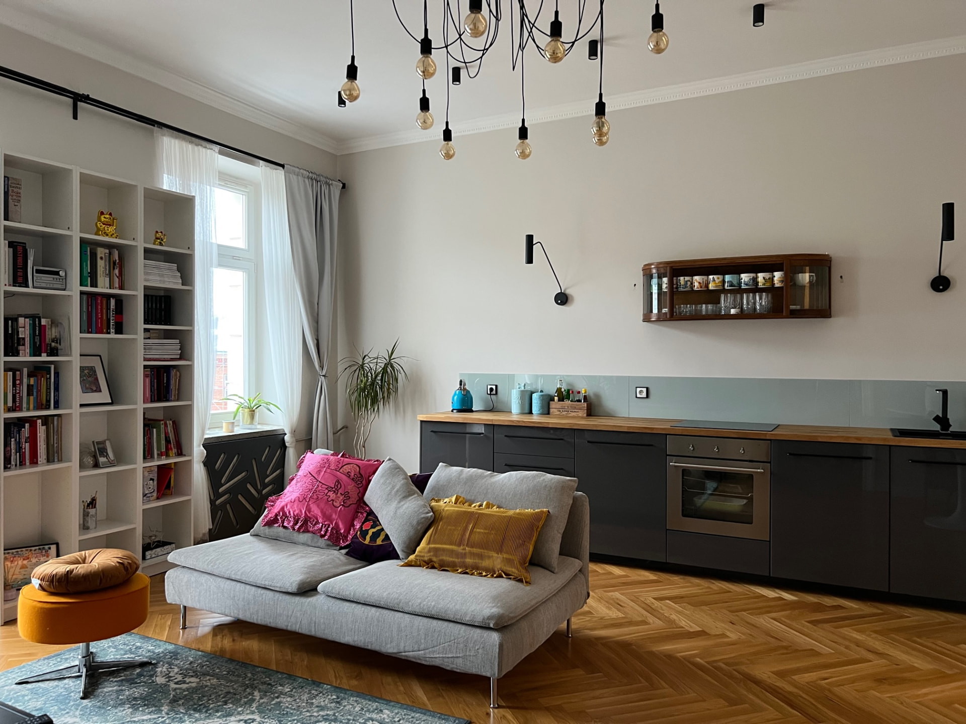 Salon z częścią kuchenną, piekarnikiem i drewnianym blatem